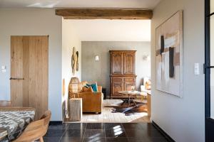 a bedroom with a bed and a living room at De Zonnebrug in Sint-Laureins