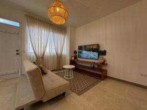 a living room with a couch and a flat screen tv at BoHo Galapagos in Puerto Ayora