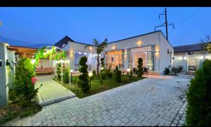 a large white house with a courtyard at night at Rest House İsmayıllı Villa in İsmayıllı