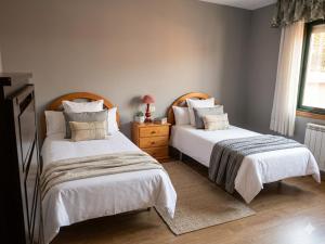 two beds sitting next to each other in a bedroom at Precioso chalet cerca de la playa de Samil in Vigo