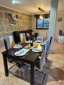 a dining room table with chairs and a living room at Precioso chalet cerca de la playa de Samil in Vigo