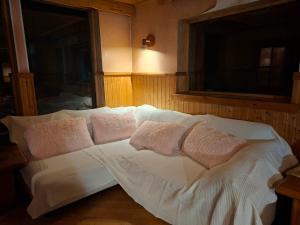 a white bed with pillows on it in a room at Finstonia Guesthouse in Vääna-Jõesuu
