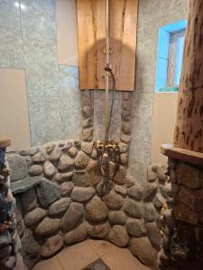 a bathroom with a stone wall and a chandelier at Finstonia Guesthouse in Vääna-Jõesuu +20 photos