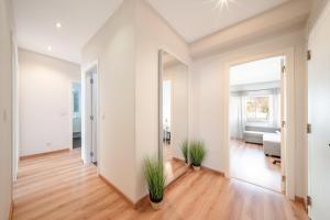 an empty living room with white walls and wood floors at GuestReady - Retreat in Almada in Almada +27 photos