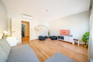 a living room with a flat screen tv on a wooden floor at GuestReady - Retreat in Almada in Almada