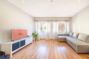 a living room with a couch and a flat screen tv at GuestReady - Retreat in Almada in Almada