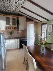 a kitchen with a wooden table and white cabinets at Seaview Tivat in Tivat