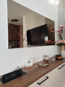 a mirror on a wall above a counter with a tv at City Studio in Smederevo