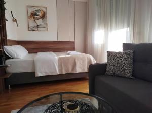 a living room with a bed and a glass table at City Studio in Smederevo