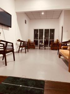 a living room with wooden furniture and a flat screen tv at Chanco Beach Hotel and Coworking - Negombo in Negombo