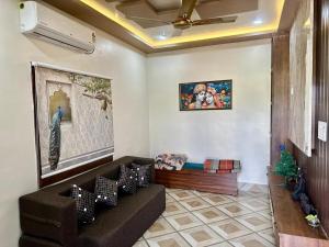 a living room with a couch and a painting on the wall at Palash Paradise in Bokāro