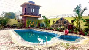 a swimming pool in front of a building with a house at Palash Paradise in Bokāro