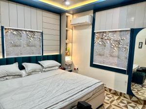 a bedroom with a large bed and two windows at Palash Paradise in Bokāro +16 photos