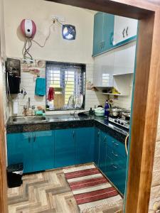 a kitchen with blue cabinets and a counter top at Palash Paradise in Bokāro