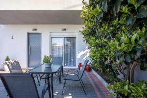 a patio with a table and chairs on a patio at Hara's Cozy Apartment with Private Parking in Rhodes Town