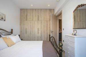 a bedroom with a bed and a wooden door at Hara's Cozy Apartment with Private Parking in Rhodes Town