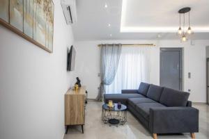 a living room with a blue couch and a table at Hara's Cozy Apartment with Private Parking in Rhodes Town