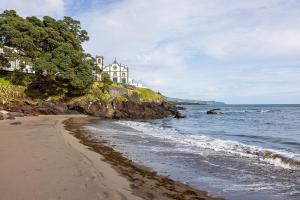a house on a cliff next to the ocean at Villa São Roque in Ponta Delgada