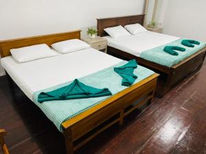 two beds in a room with blue towels on them at Chanco Beach Hotel and Coworking - Negombo in Negombo