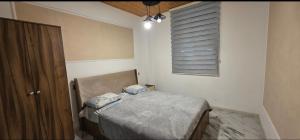 a small bedroom with a bed and a window at Rest House İsmayıllı Villa in İsmayıllı +3 photos