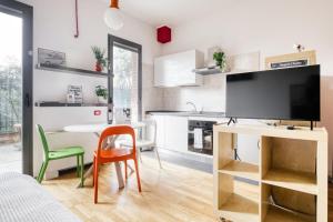 a living room with a table and a tv and a kitchen at Linate Airport - Apt with Garden in Milan