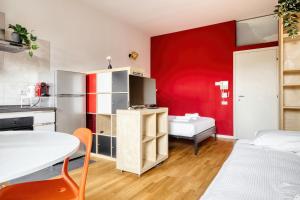 a room with a red wall and a table and a bed at Linate Airport - Apt with Garden in Milan