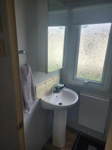 a bathroom with a sink and a window at 2 Vale Park in Fishguard +19 photos
