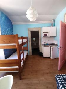 a small room with a bunk bed and a kitchen at Meeting Hostel in Figueira da Foz