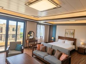 a bedroom with a bed and a couch and a table at Seaview Garden Hotel & Residences in Trinity