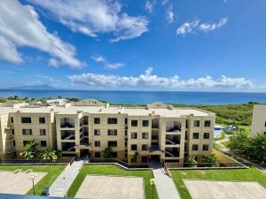 an apartment building with the ocean in the background at Seaview Garden Hotel & Residences in Trinity
