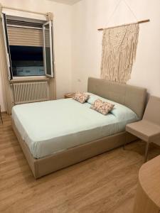 a bedroom with a bed and a chair and a window at Pepe Apartments Asy in Castellammare di Stabia
