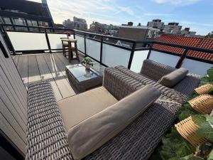a balcony with a couch and a table on a roof at Studio Casa Martine in Noordwijk aan Zee
