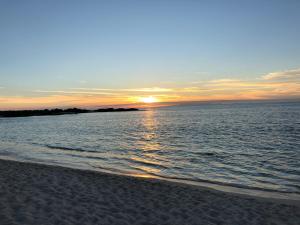 a sunset over the ocean with a sandy beach at BoHo Galapagos in Puerto Ayora