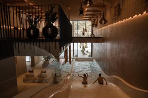 two people sitting in a swimming pool in a house at Hotel Masl in Valles +120 photos