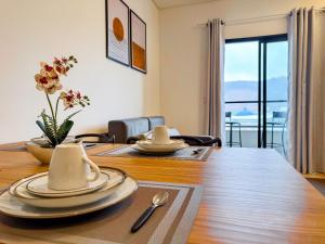 a dining room with a table with plates and utensils at Flat moderno com churrasqueira próximo à Unifebe in Brusque