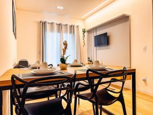 a dining room with a table and four chairs at Flat moderno com churrasqueira próximo à Unifebe in Brusque