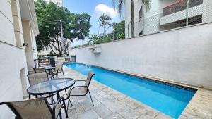 a patio with a table and chairs next to a swimming pool at Flat Moema Apart La Maison D´Stan 02 DTS - UH82 in São Paulo