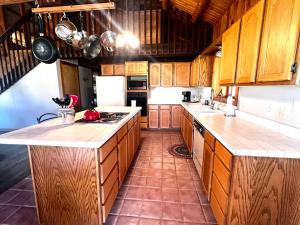 a kitchen with wooden cabinets and white counter tops at Selway View Cabin in Corvallis
