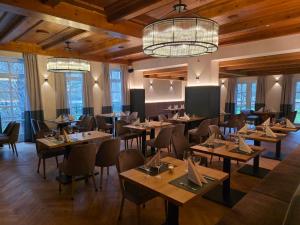 a restaurant with wooden floors and tables and chairs at Hotel und Weingut Karlsmühle in Mertesdorf