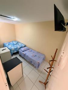 a small room with two beds and a flat screen tv at Pousada Extensão Sabrinna in Maceió +38 photos