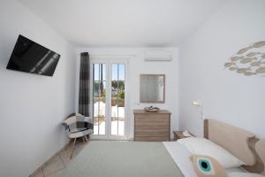 a bedroom with a bed and a tv on a wall at Sunset 7.59 in Mikonos