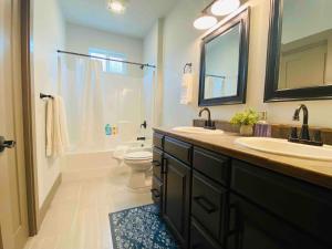 a bathroom with a sink and a toilet and a mirror at Comfy 4 Bdrm House with Air Conditioning in Corvallis +10 photos
