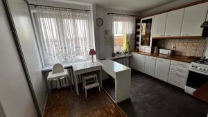 a kitchen with white cabinets and a desk and a window at Cracow View Rooms in Krakow +3 photos
