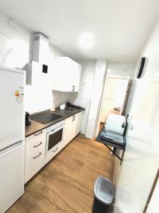 a kitchen with white cabinets and a white refrigerator at CITYHOUSE! NUEVO REFORMADO CONFORT WIFI TV65 AC FULL Visco in San Fernando +9 photos
