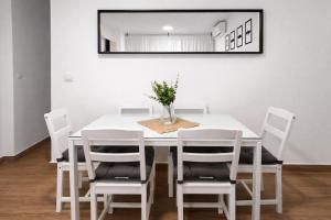 a white dining room table with white chairs and a mirror at CITYHOUSE! NUEVO REFORMADO CONFORT WIFI TV65 AC FULL Visco in San Fernando
