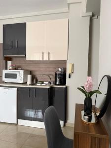a kitchen with black and white cabinets and a table at Alpha apartment 43 in Serres