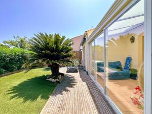 a patio with a palm tree on a deck at Mediterranean Garden in Agde