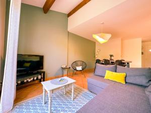 a living room with a couch and a tv at Mediterranean Garden in Agde