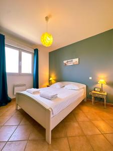 a bedroom with a large white bed with blue walls at Mediterranean Garden in Agde