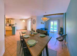 a dining table and chairs in a living room at Mediterranean Garden in Agde